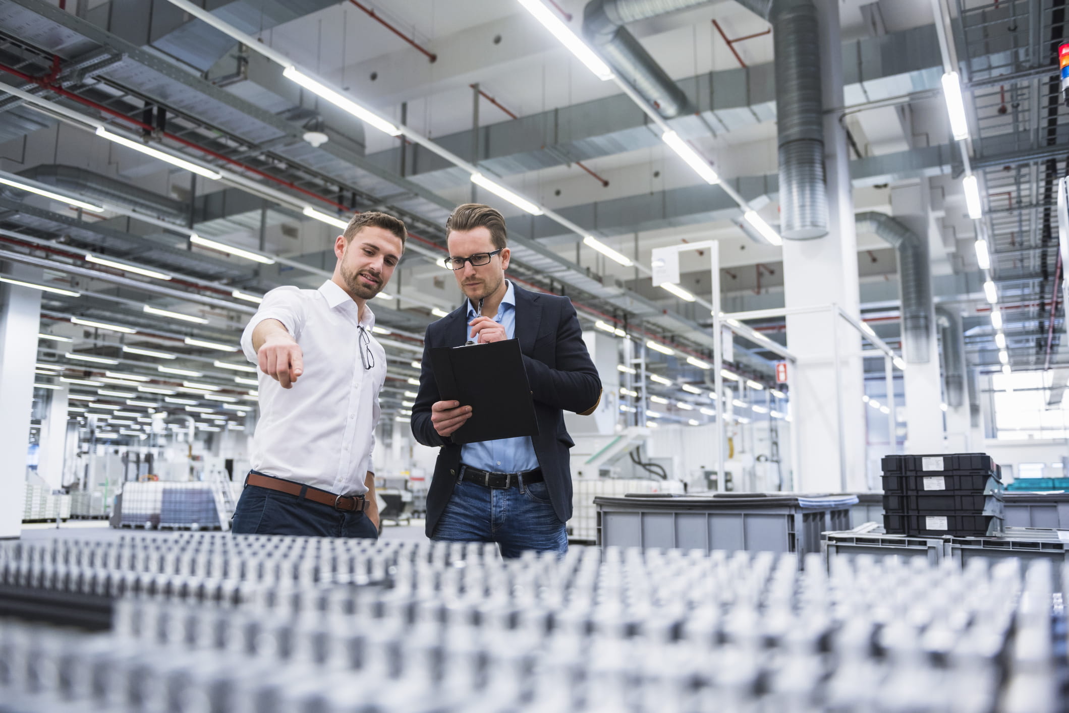 Twee mannen praten in een fabriek