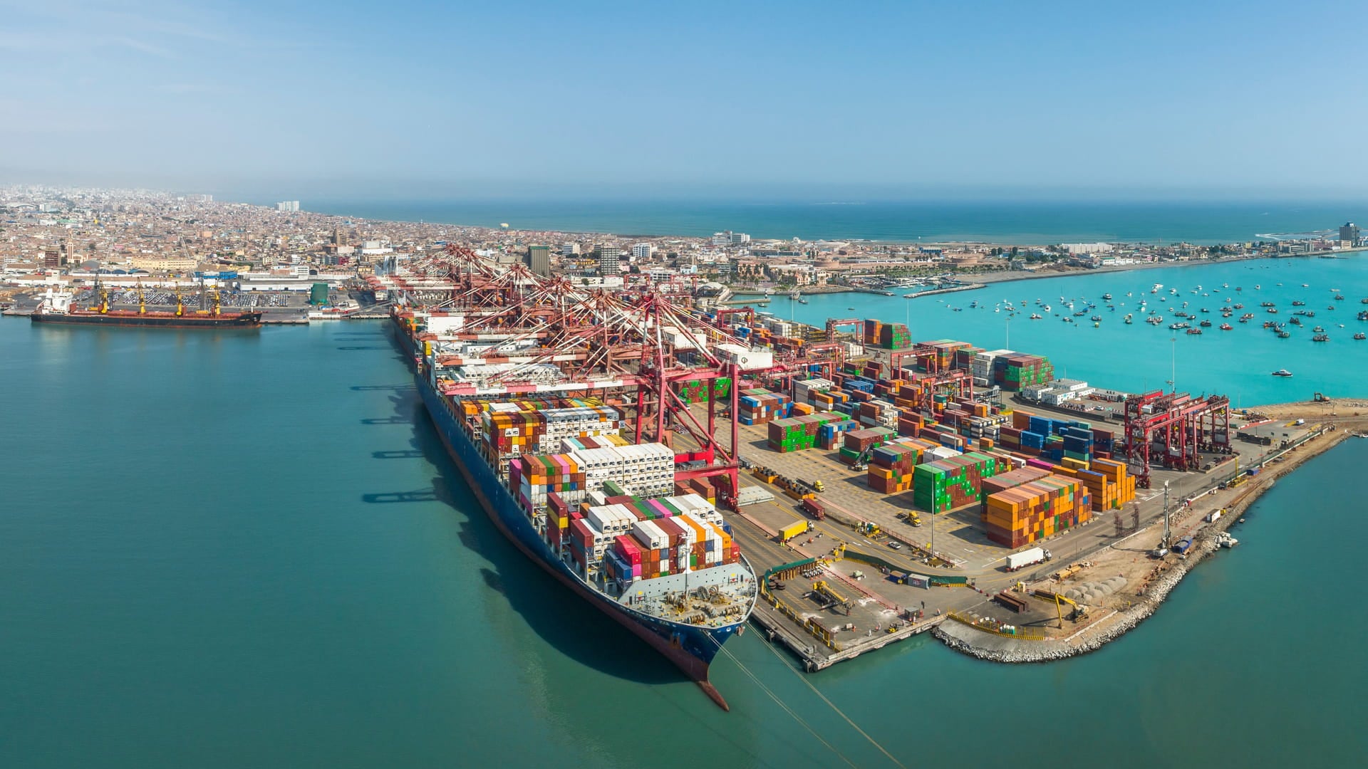 Aerial view of the port of Callao in Lima, Peru, Latin America showing port activity with containers and cranes in full operation. In the background can be seen the Pacific Ocean