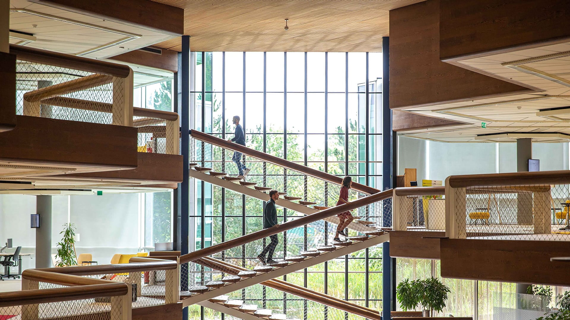 Consulting engineers walk up the sunlit stairs in the Amersfoort office of an engineering consultancy.