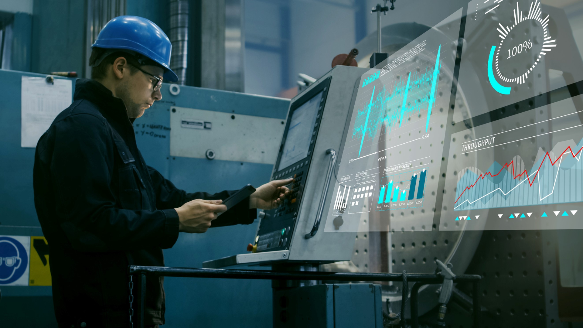 An operator working at a computer monitoring performance of a manufacturing facility.