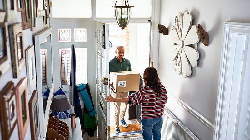A package delivery at the door, demonstrating the efficiency of delivery service providers in the retail and ecommerce industry as part of comprehensive consumer services