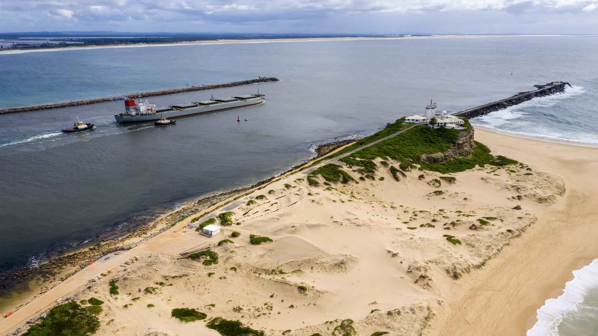 Ship leaving Newcastle Harbour with Nobbys Headland