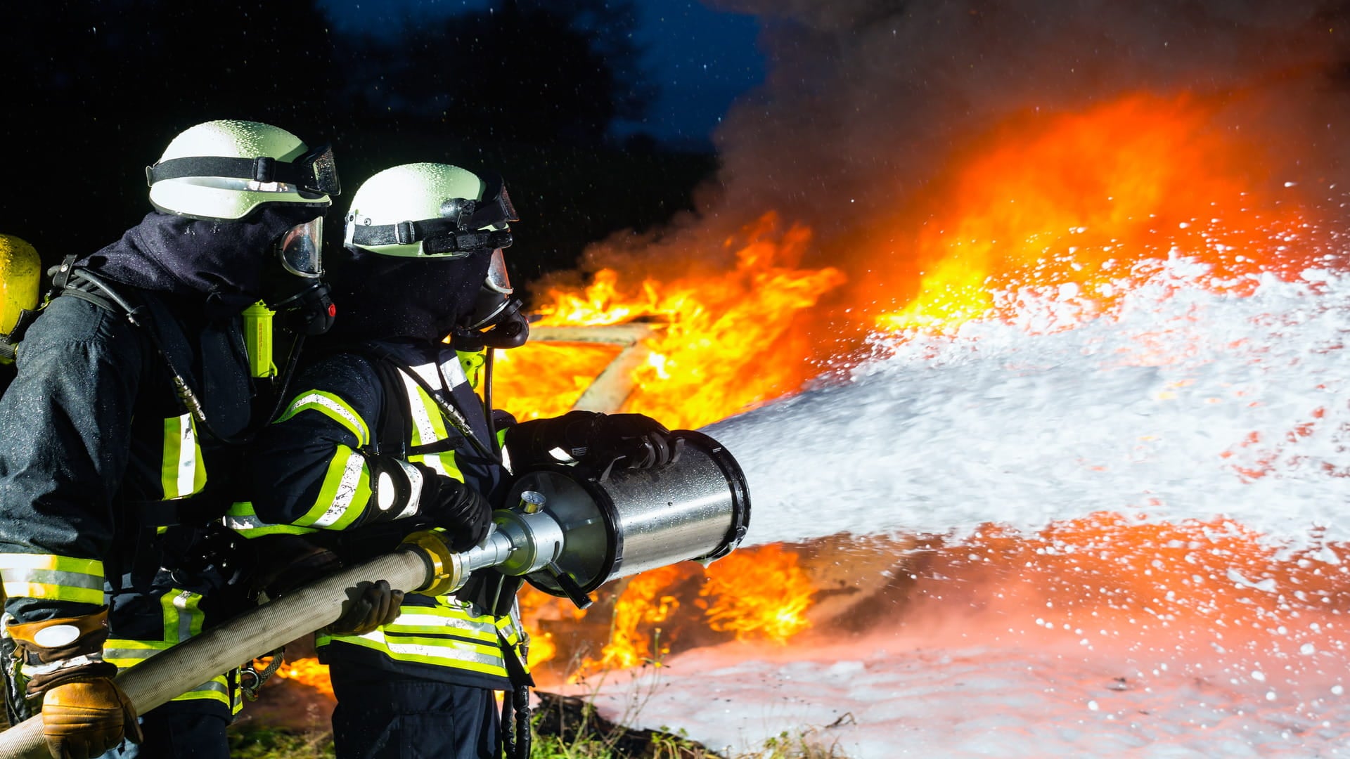 Firefighters applying firefighting foam during an emergency response, highlighting PFAS foam replacement with fluor‑free, fluorine‑free foam, foam transition strategies, EU PFAS ban, REACH regulation, and fire safety compliance.