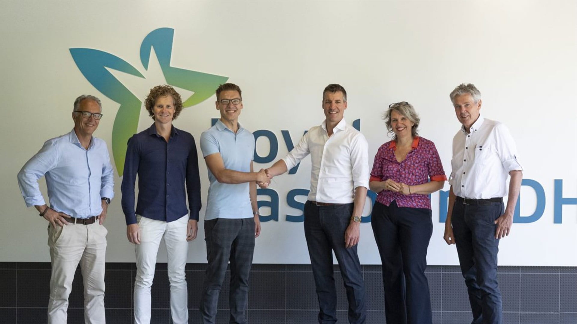 Colleagues from RHDHV standing in front of the Amersfoort office shaking hands