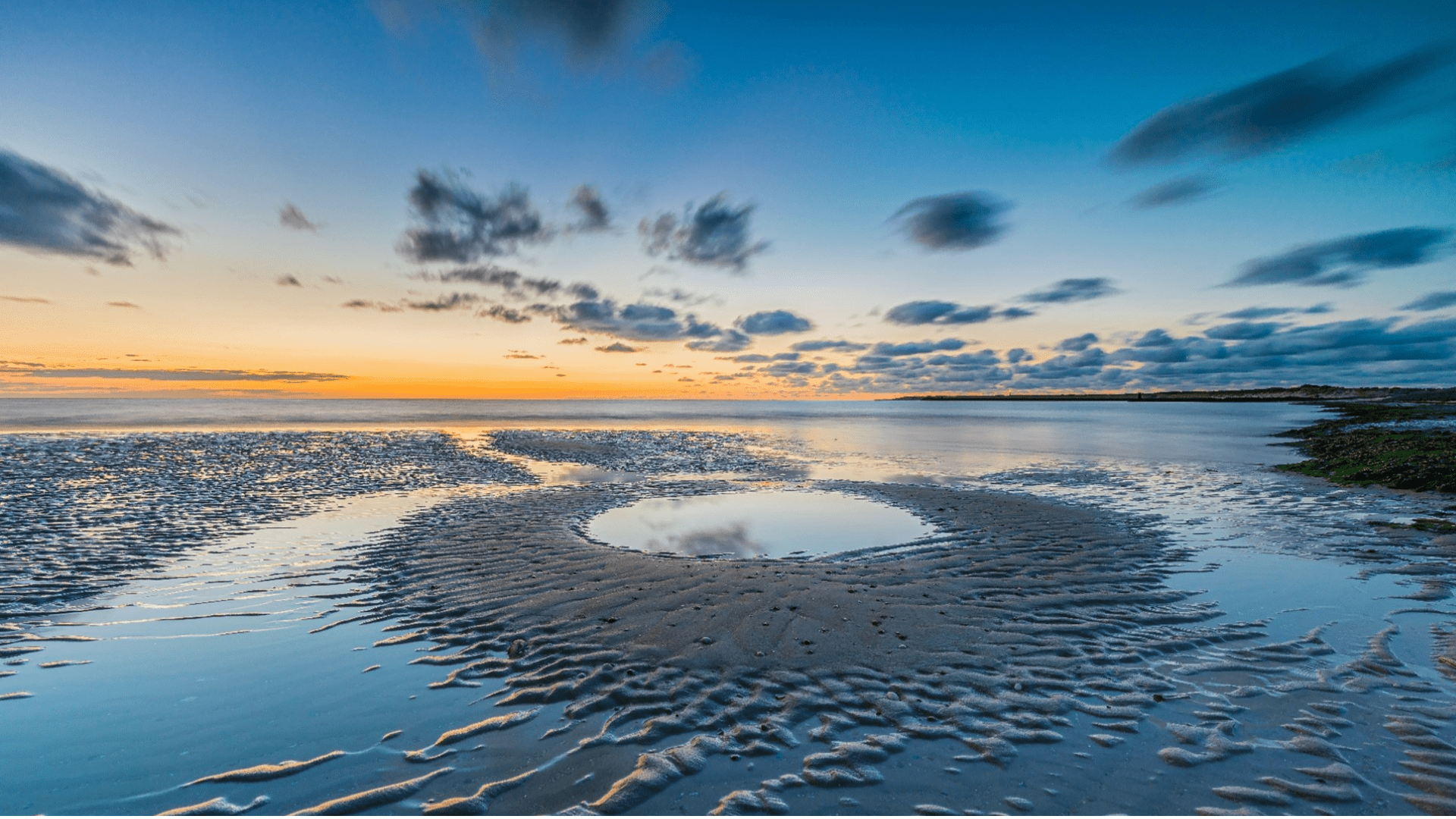 Ariel photo of ocean with sunset in the background
