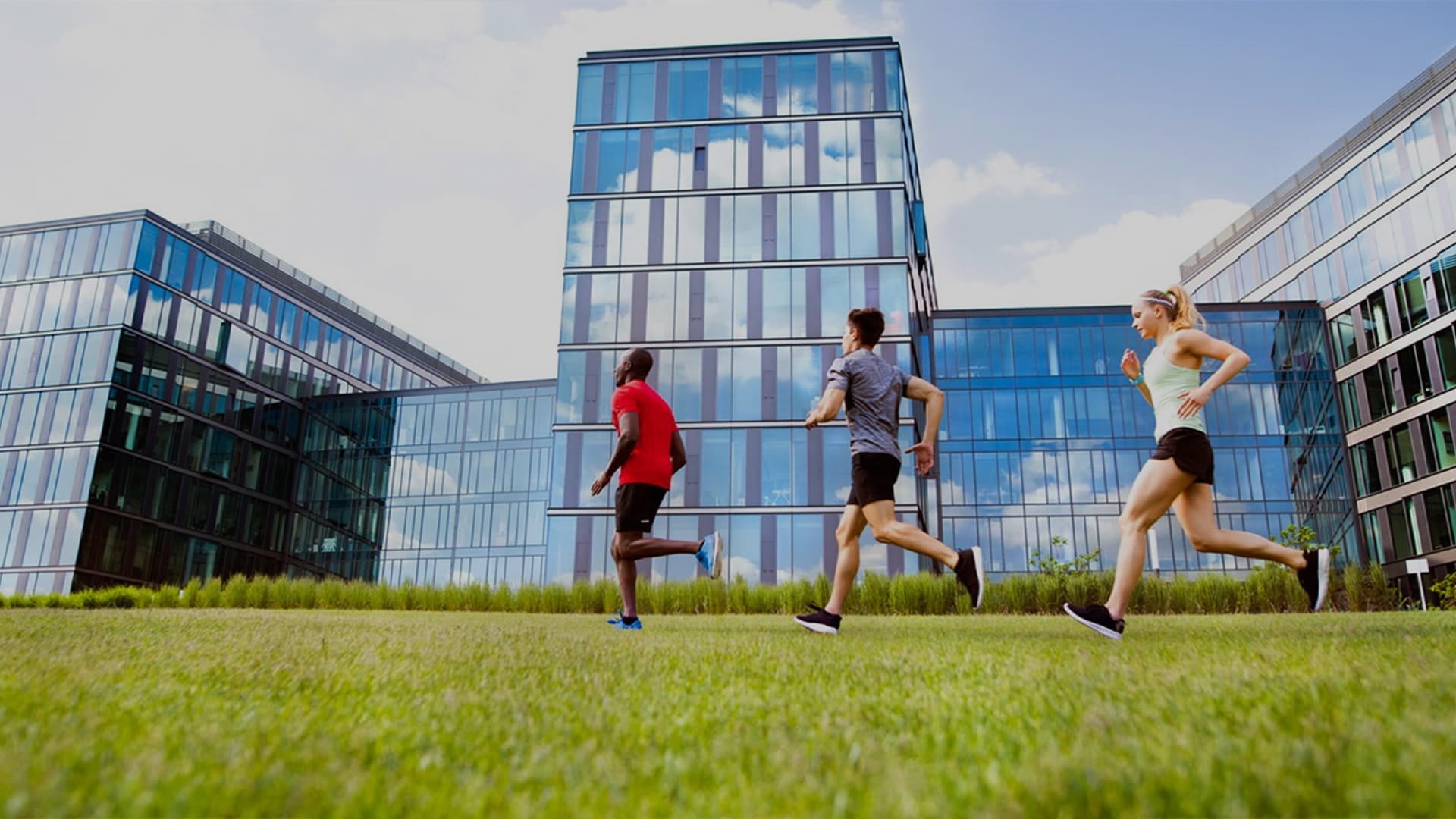 healthy employees jogging in front of a fitwell certified, smart campus workplace 