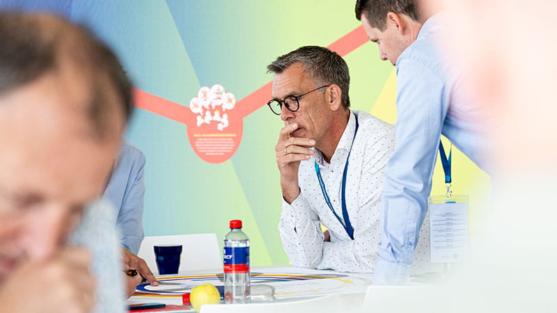 3 people gazing thoughtfully at a game board