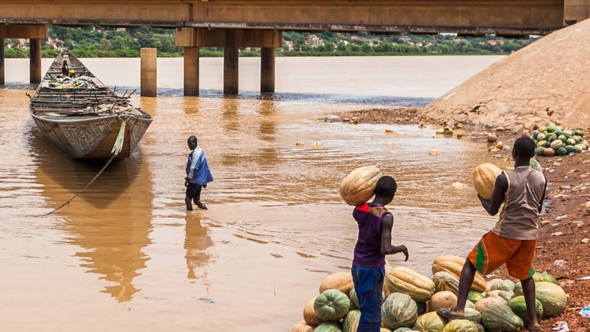 Locals standing at the shore of a river in Nigeria