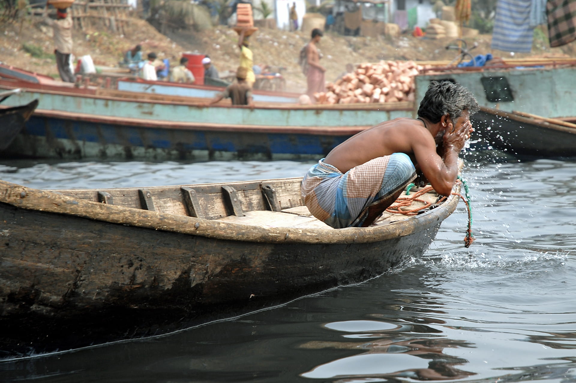 Man in Dhaka washing his face in the river