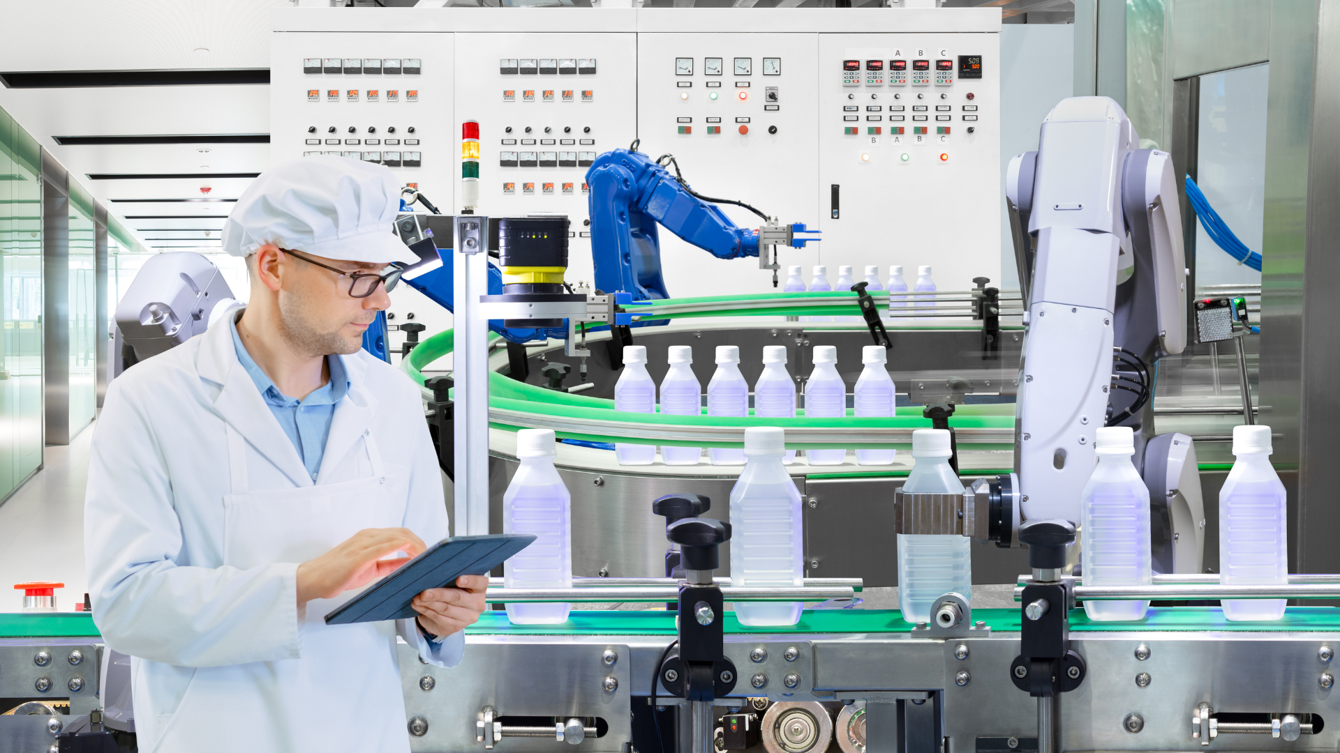 Industrial project delivery in automated manufacturing facility with robotic production line and engineer using tablet, showcasing integrated engineering, EPCM and digital optimisation for efficient and safe industrial capital projects