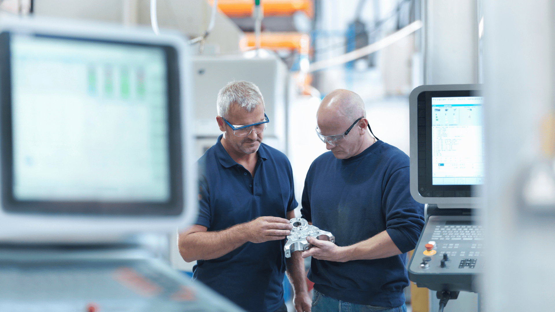 Technicians inspecting industrial component in manufacturing facility to improve asset performance and ensure operational excellence in asset-intensive industry