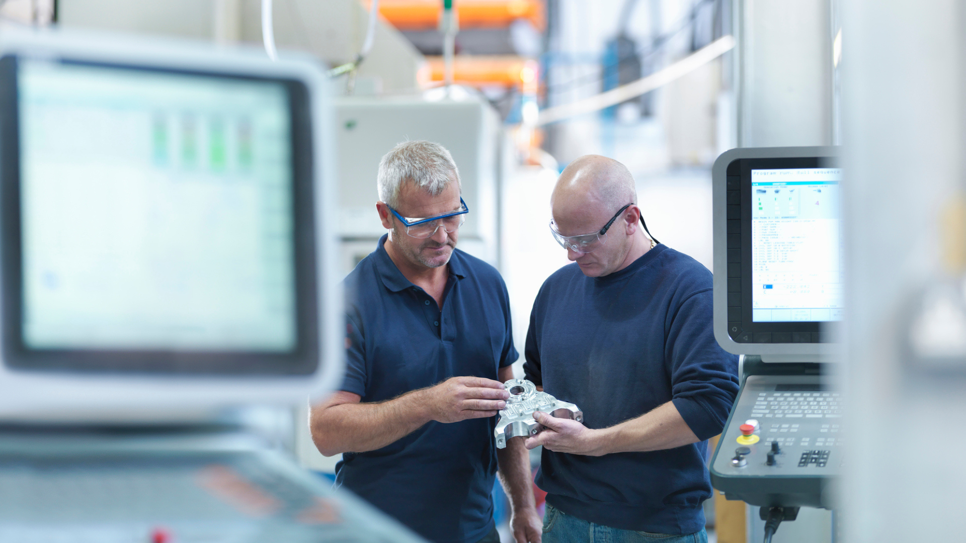 Technicians inspecting industrial component in manufacturing facility to improve asset performance and ensure operational excellence in asset-intensive industry