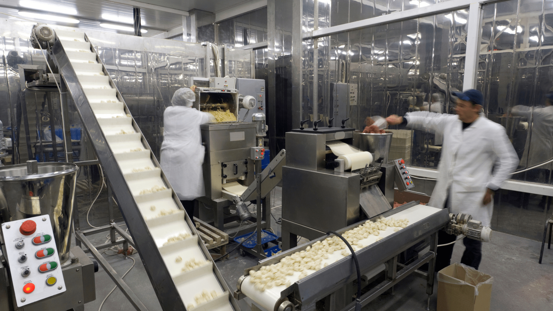 Automated food production line with operators in manufacturing facility, demonstrating operational excellence and high-performance operations in asset-intensive industry