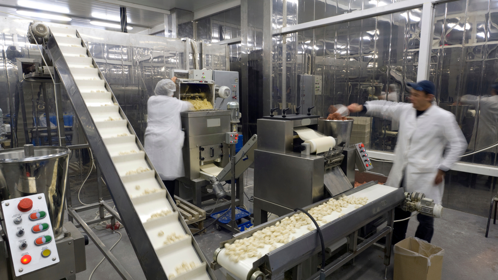 Automated food production line with operators in manufacturing facility, demonstrating operational excellence and high-performance operations in asset-intensive industry