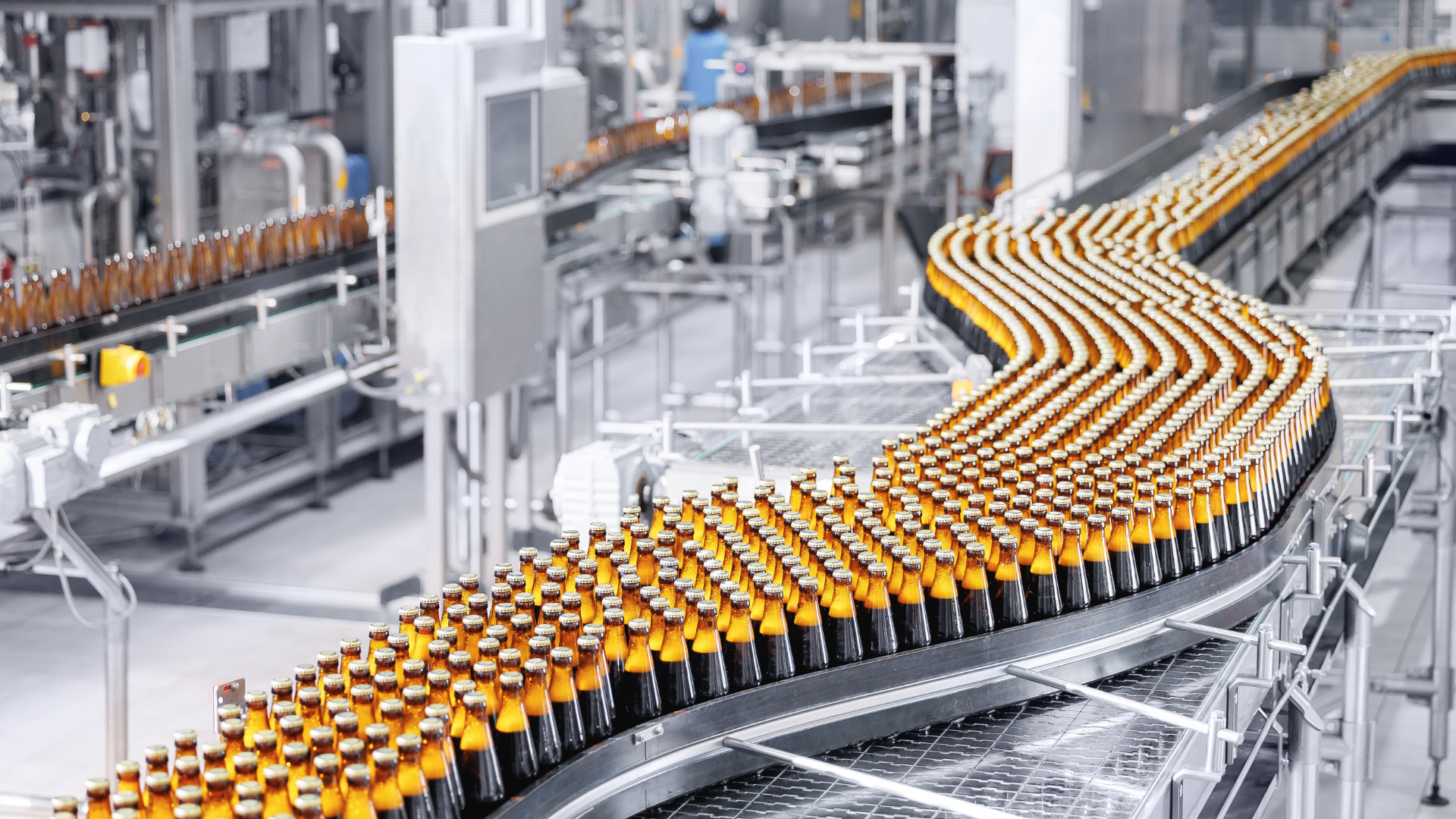Automated beverage bottling line in manufacturing plant, demonstrating high-performance operations and operational excellence in asset-intensive industry