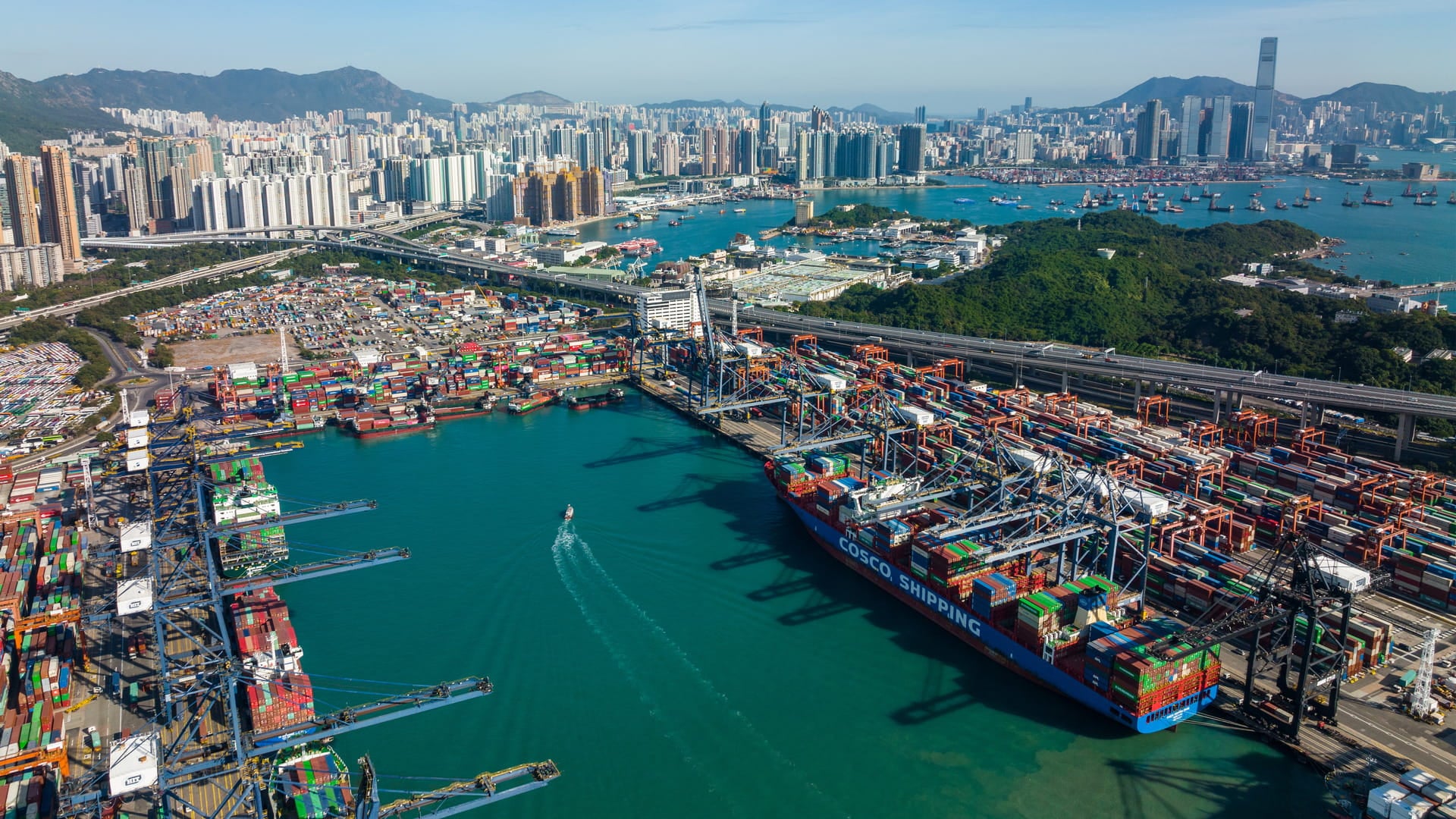 A large container ship docked at a port. Green port strategy aims to reduce pollution and waste produced by ports and ships.