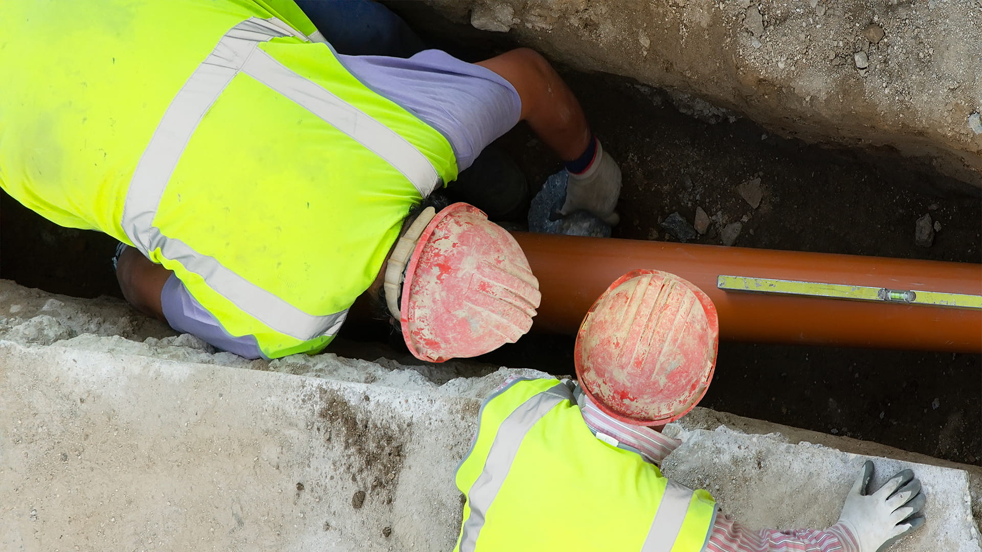 construction workers lay sewer drainage pipes