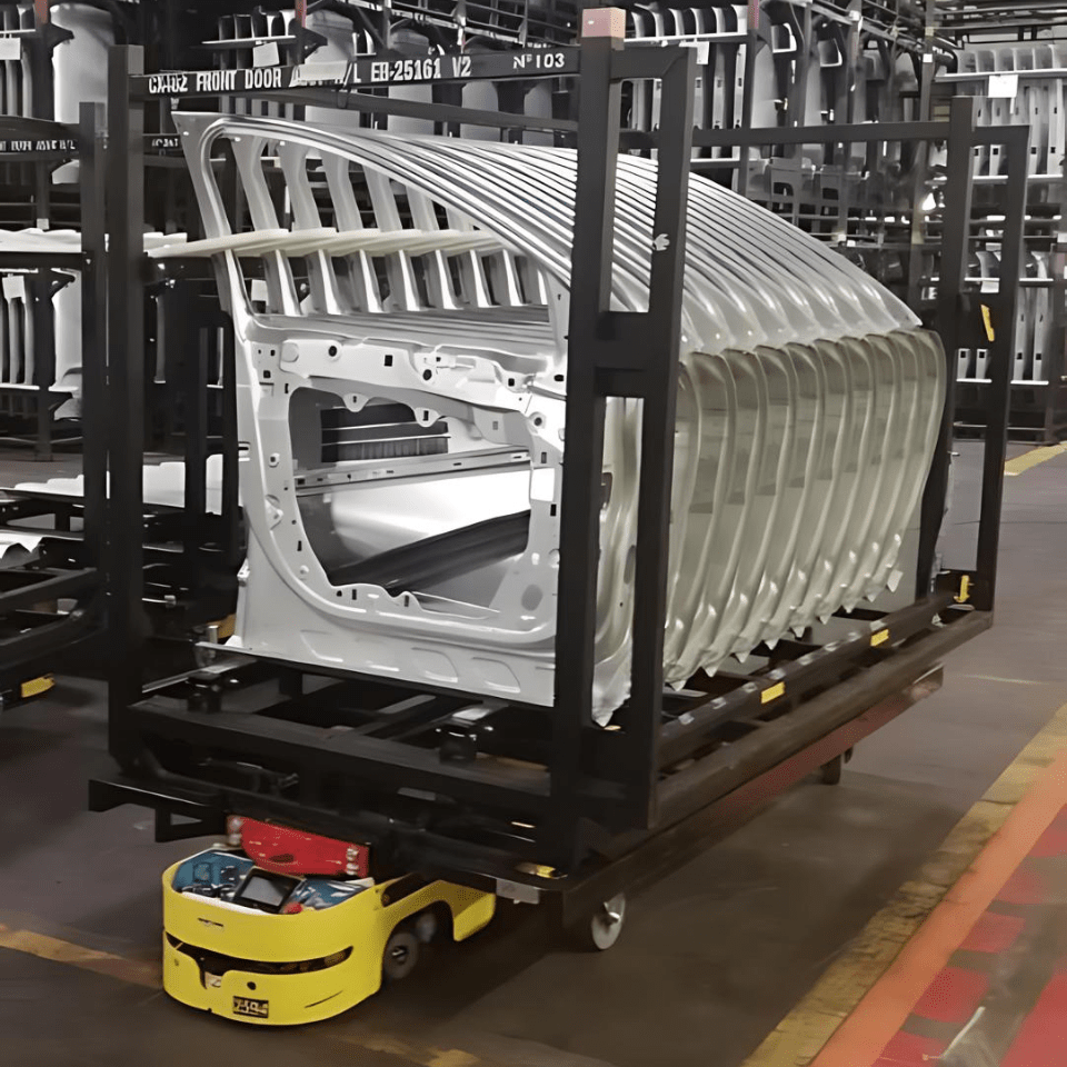 An agv carries car doors inside of the manufacturing plant