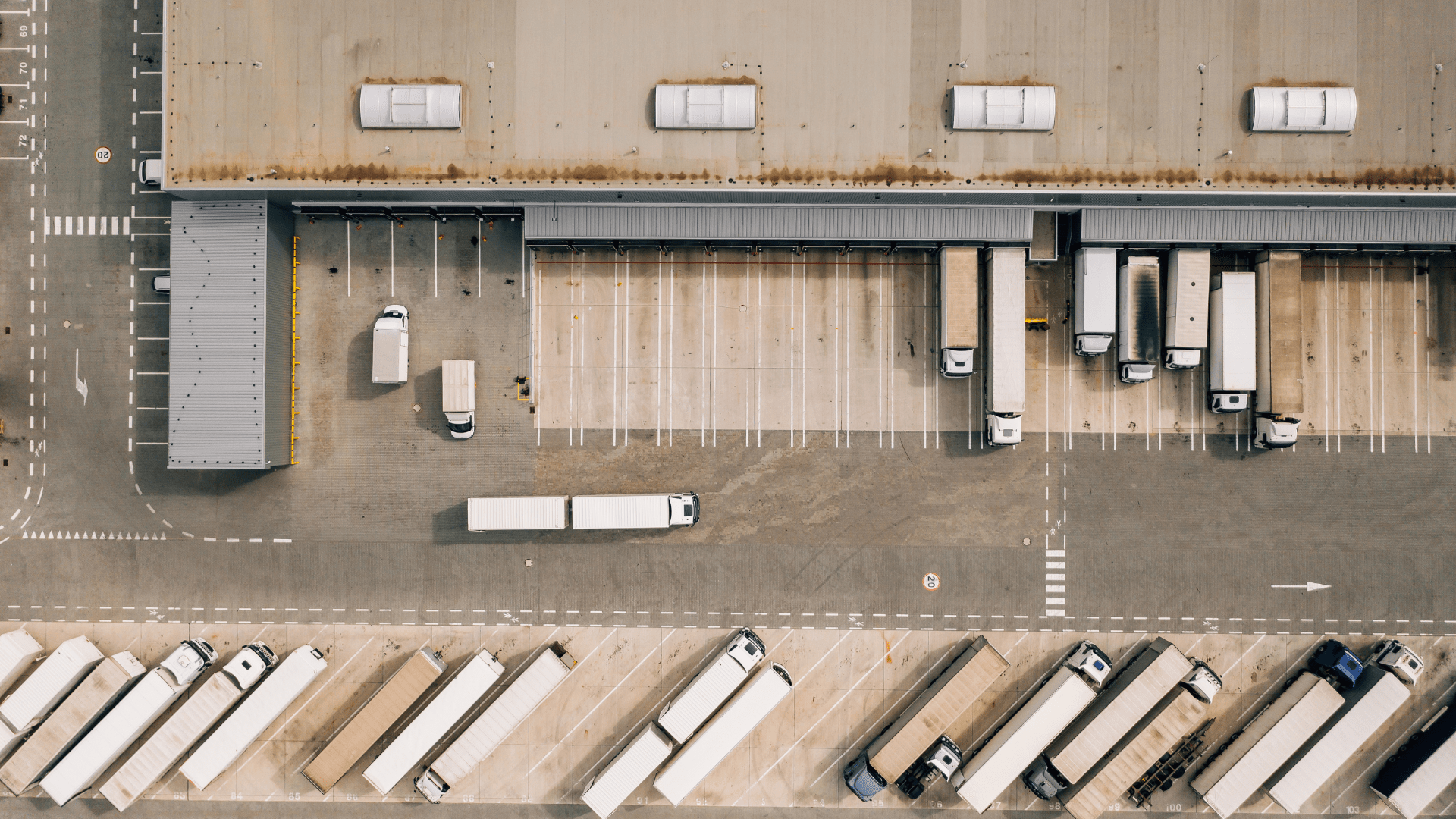A view from above of a logistics facility with trucks at the loading bays