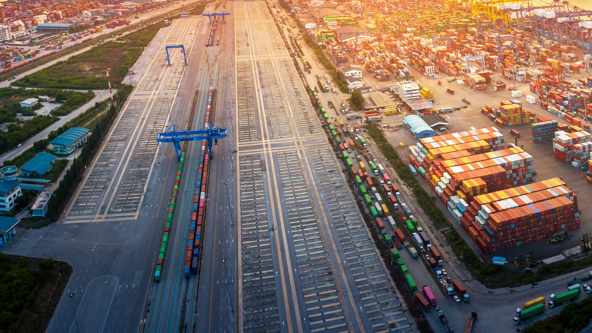an aerial view of a transport network at a busy dock with shipping containers