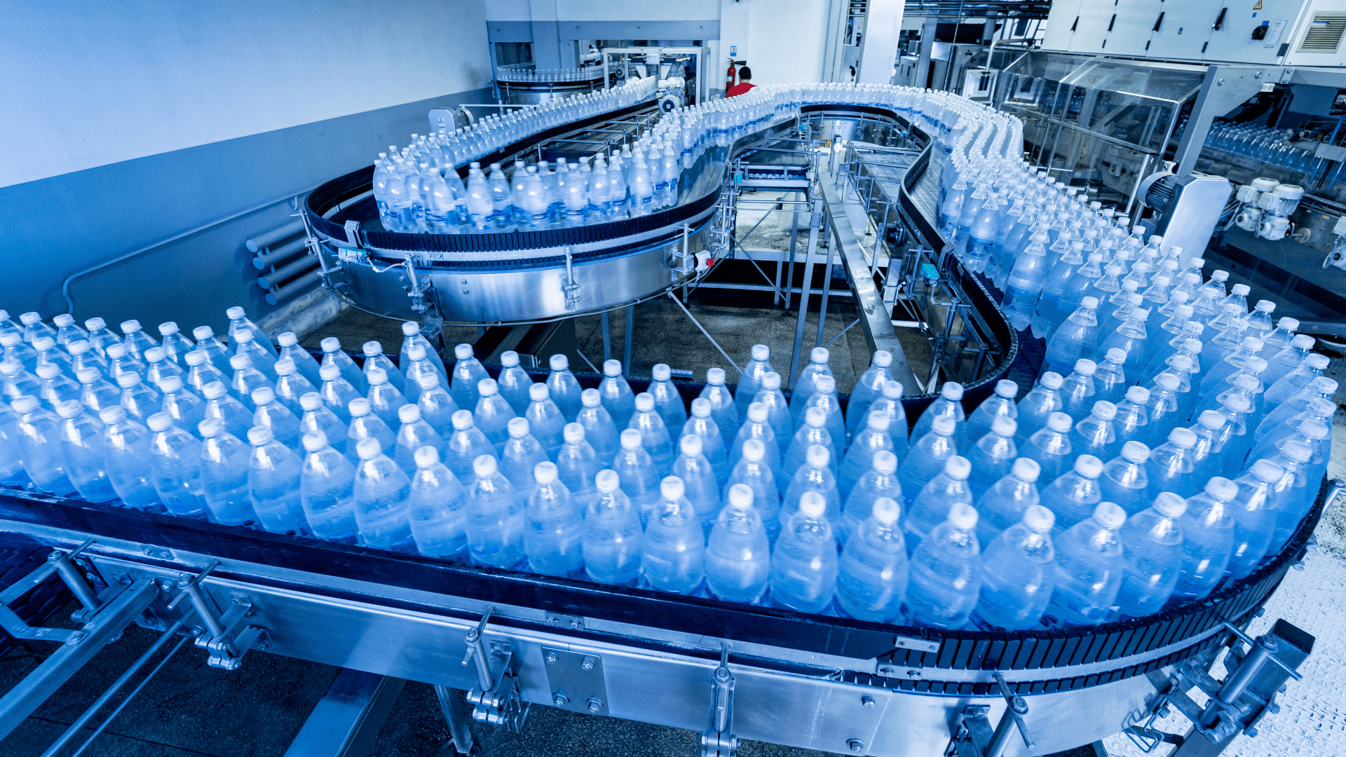 Water bottles move down a conveyor in food and beverage facility