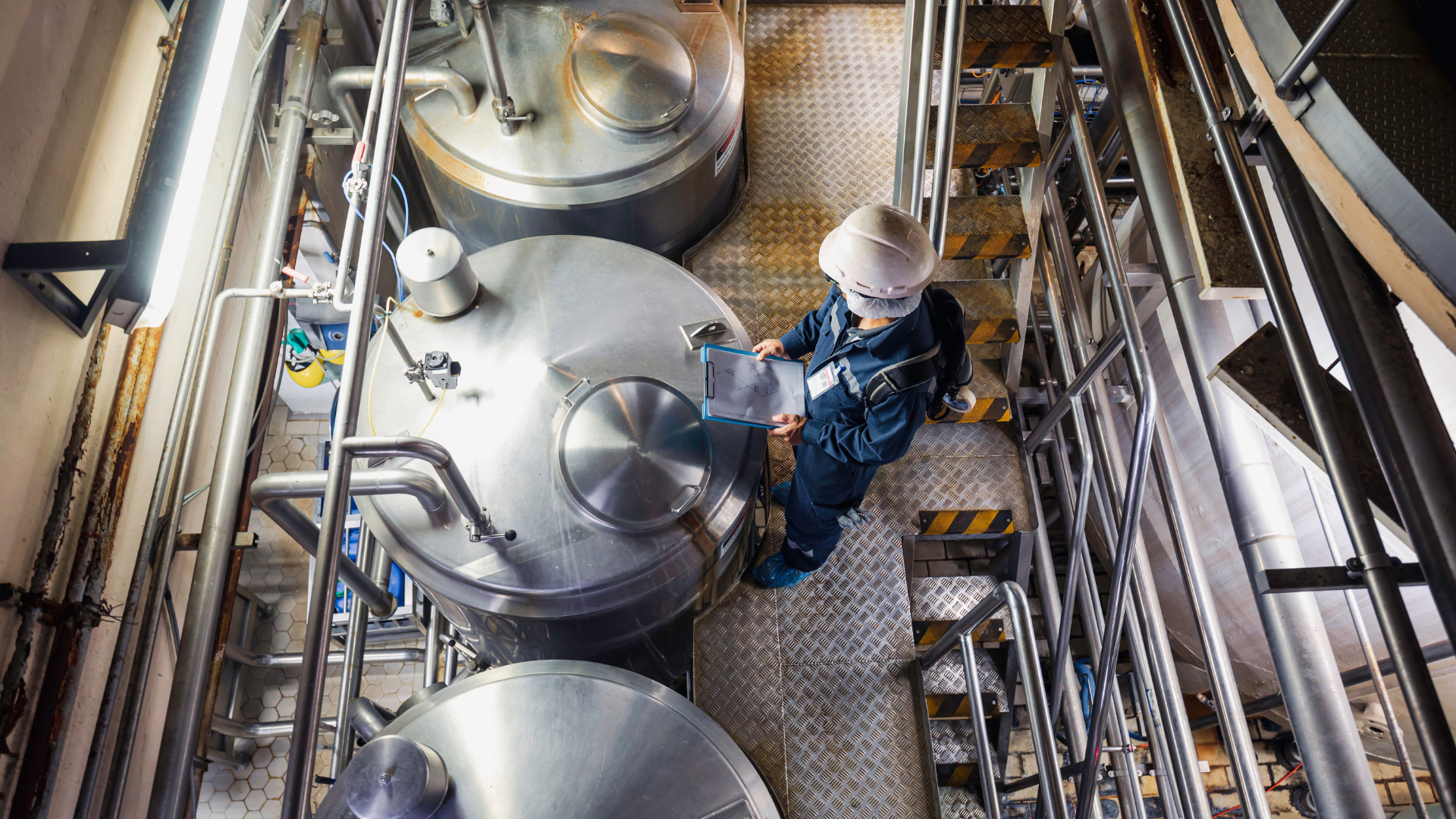 An operator checks operations at a commercial brewery
