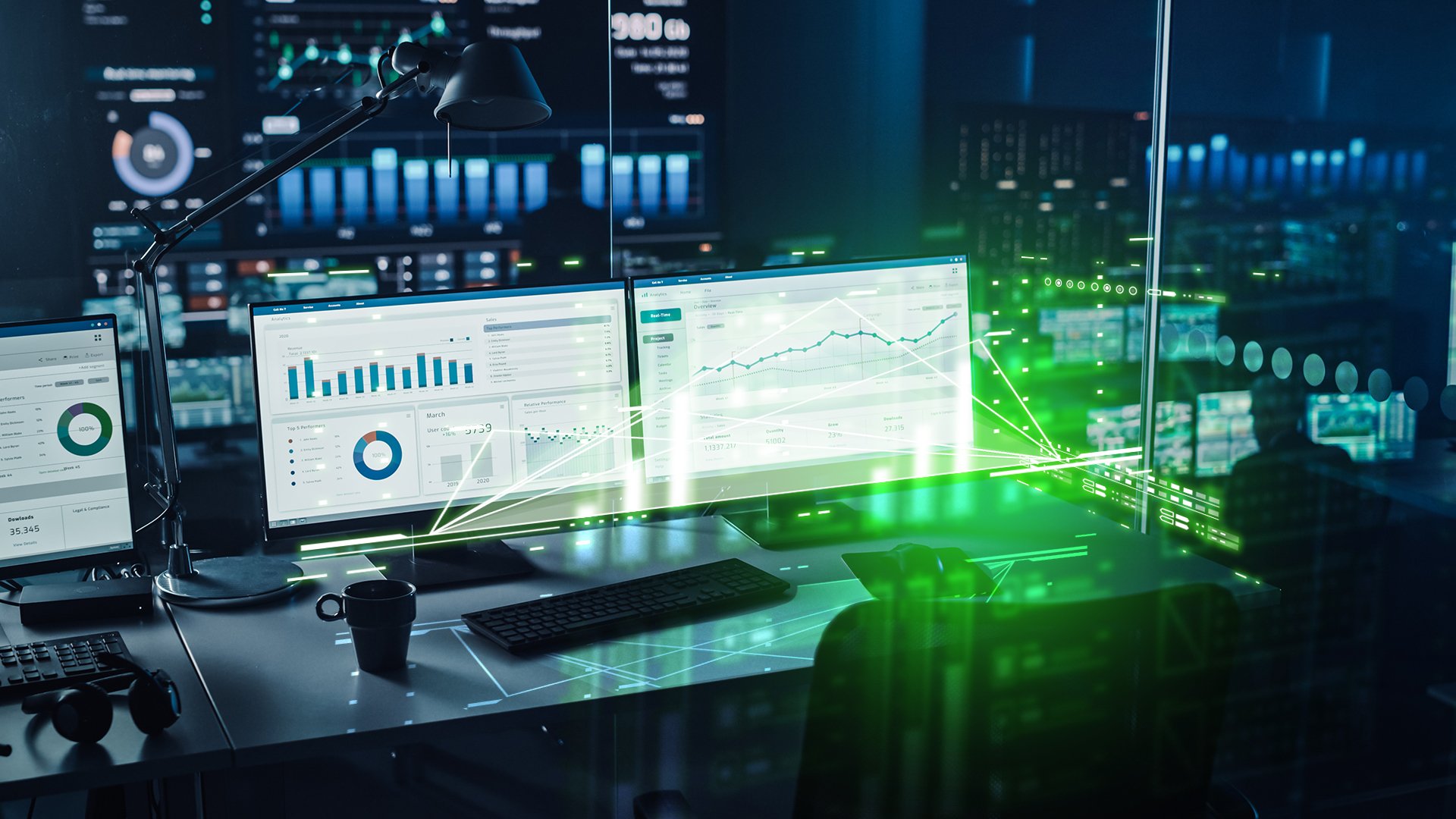 Night view of multiple PCs on a desk, each displaying data solution dashboards for Twinn products