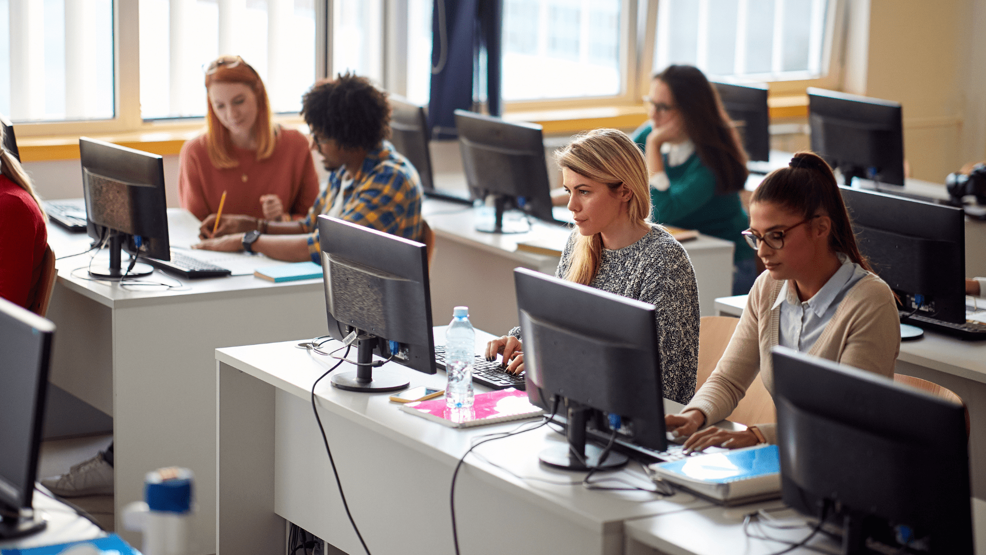 A classroom with several people working at computers